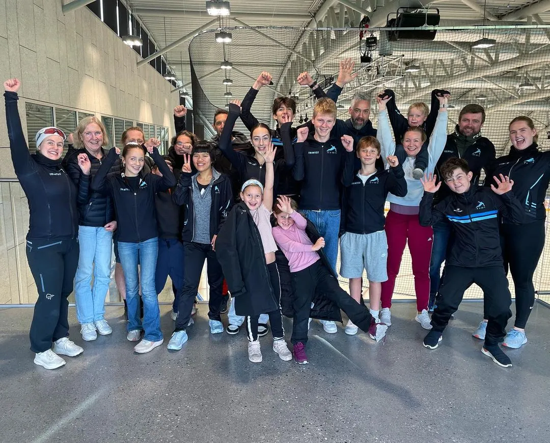 The short track speed skating team celebrating on the grandstand, showing excitement and pride after their successful performance.